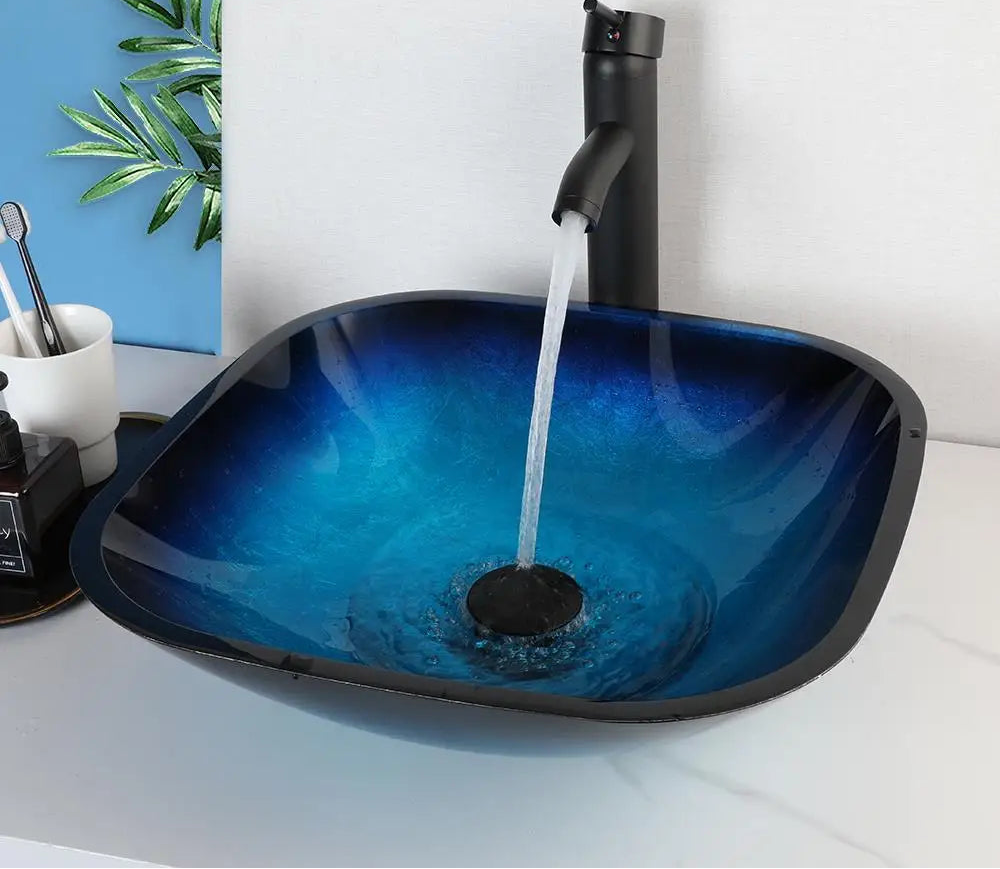 MC THE BLACK DIAMOND ZAPPO tempered glass bathroom vessel sink with black waterfall faucet, oval blue above-counter basin.