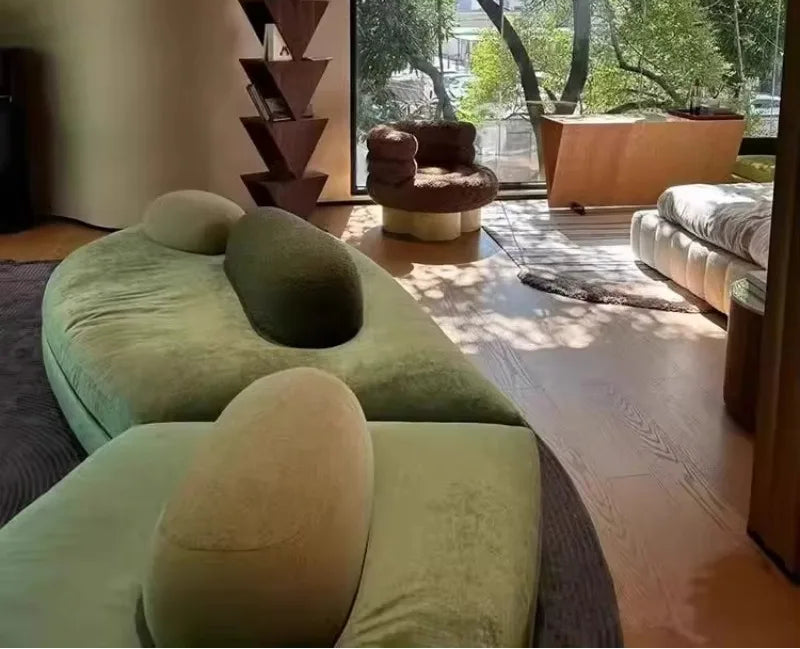 Large green fabric sectional sofa by MC THE BLACK DIAMOND, featuring a French pebble design with a unique arc-shaped modular layout.