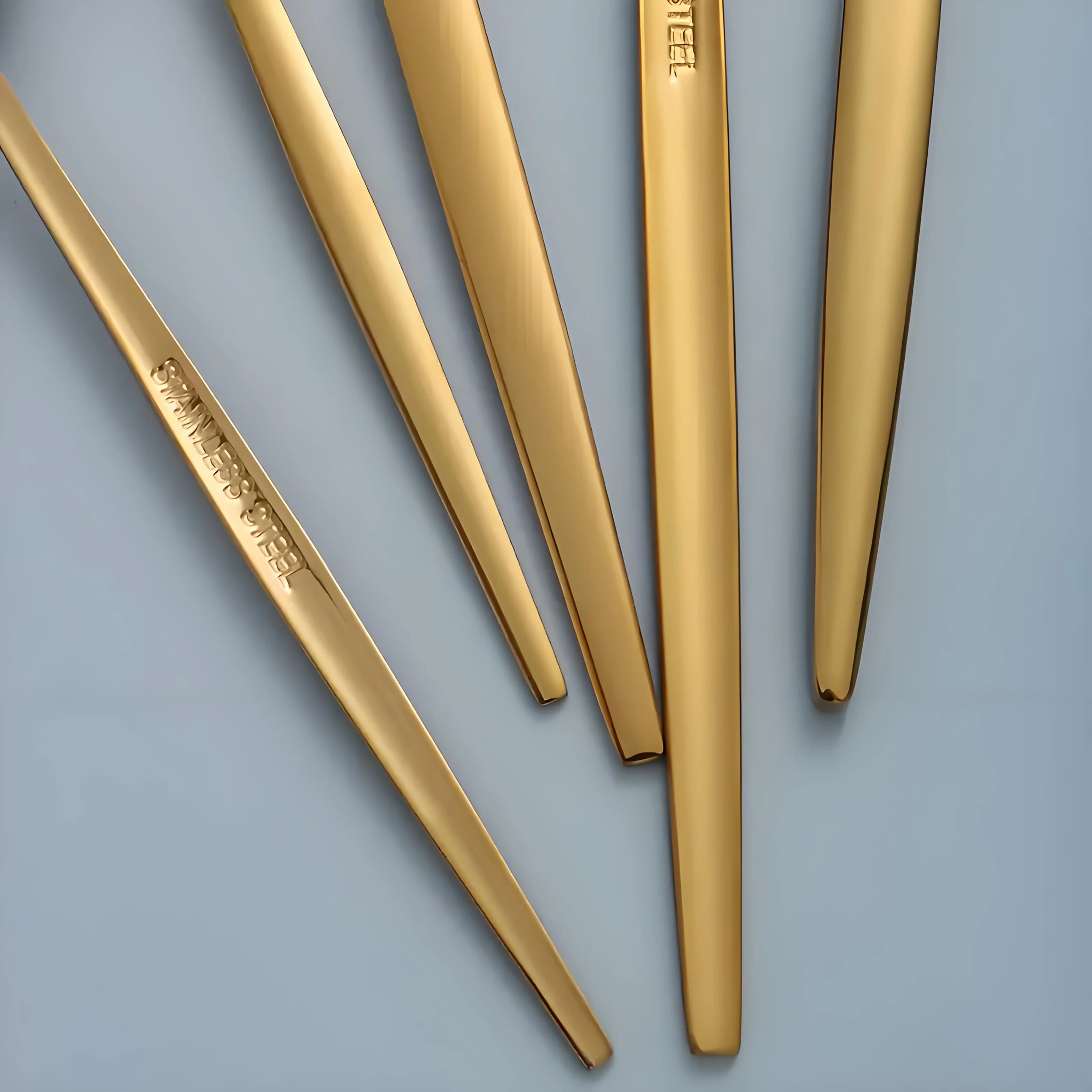 Set of 30 golden and silver cutlery pieces from MC The Black Diamonds, featuring forks, knives, and spoons arranged on a table.