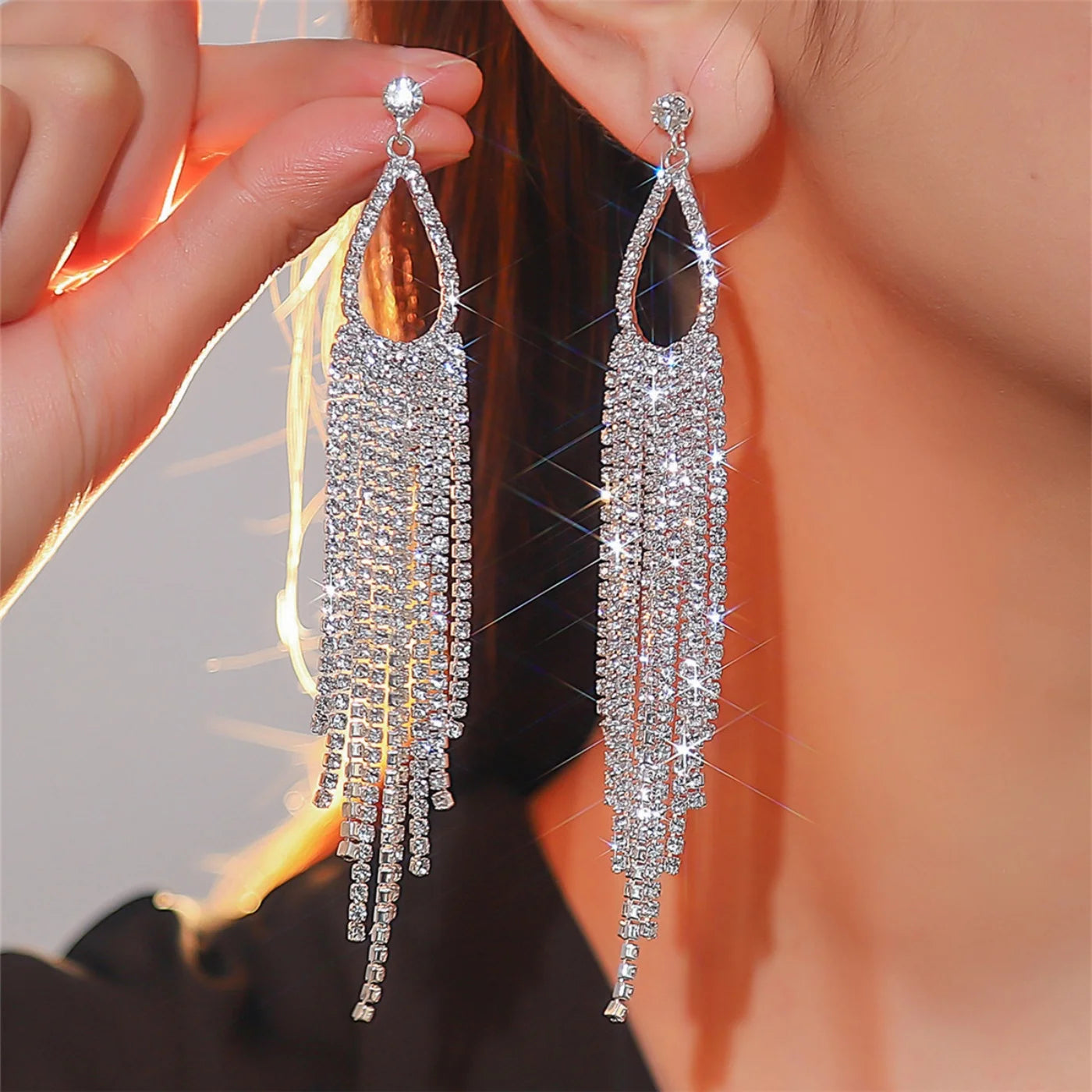 Pair of women's jewelry rhinestone tassel earrings by MC The Black Diamonds featuring sparkling rhinestones and elegant tassels.