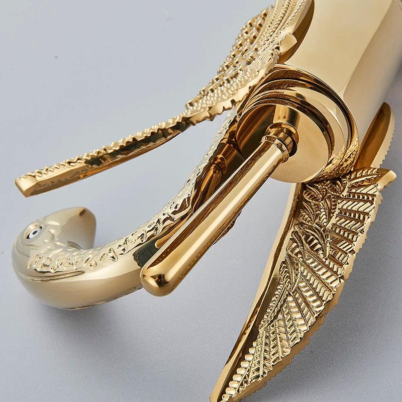 MC THE BLACK DIAMOND golden basin deck mount faucet with swan-shaped spout and single handle for hot and cold water in a bath sink.