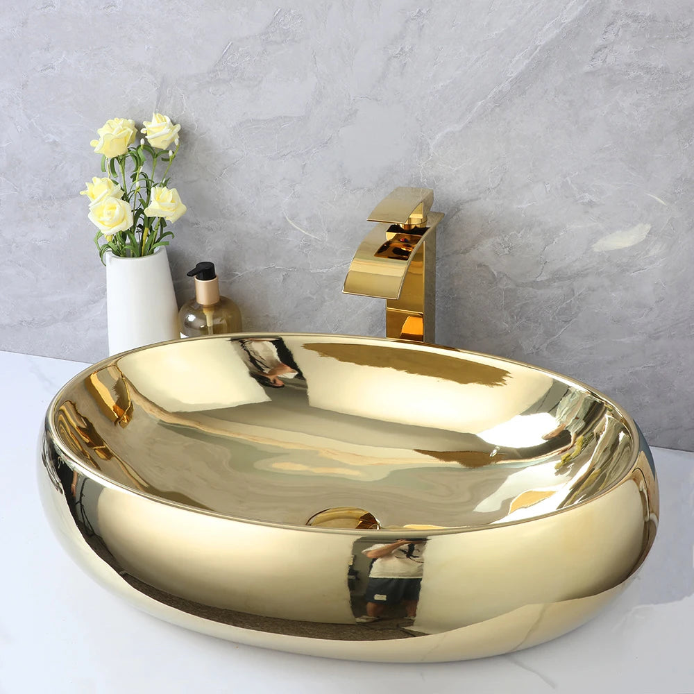 Luxury MC THE BLACK DIAMOND 23-inch gold ceramic bathroom vessel sink with oval shape and gold waterfall faucet mixer.