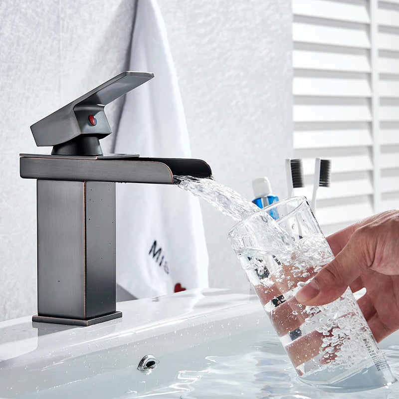 Black waterfall bathroom faucet and basin vanity vessel sink by MC The Black Diamond, showcasing sleek modern design and smooth water flow.