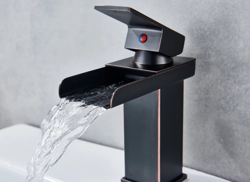 Black waterfall bathroom faucet and basin vanity vessel sink by MC THE BLACK DIAMOND, shown in a modern bathroom setting.