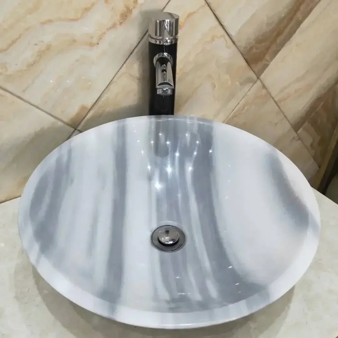 Handmade rose quartz vessel sink for bathroom decor, featuring a smooth, polished pink quartz bowl with elegant design.