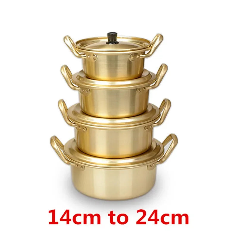 MC THE BLACK DIAMOND Korean style ramen noodles hot pot in gold aluminum cookware, with eggs and noodles inside on a kitchen countertop