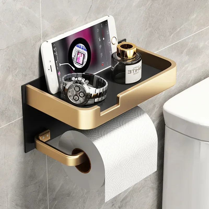 Black gold toilet paper holder by MC THE BLACK DIAMOND mounted on bathroom wall with a roll of toilet paper