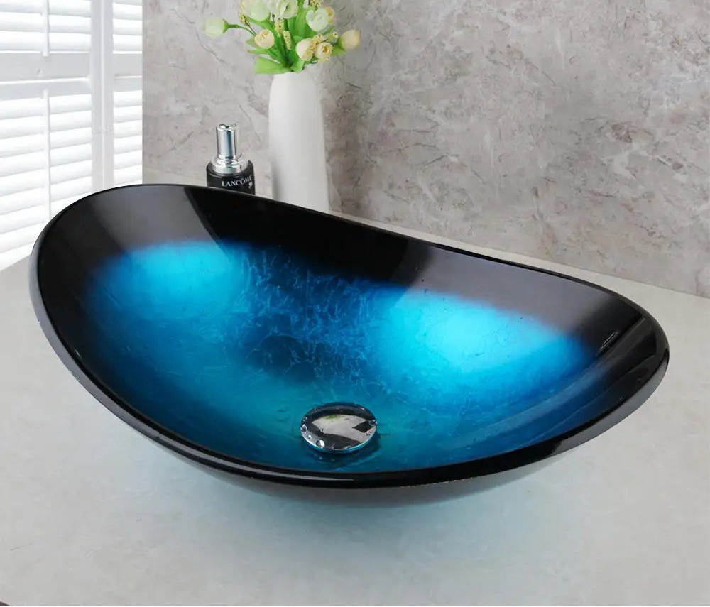 MC THE BLACK DIAMOND ZAPPO tempered glass bathroom vessel sink with waterfall black faucet, oval blue above counter basin.