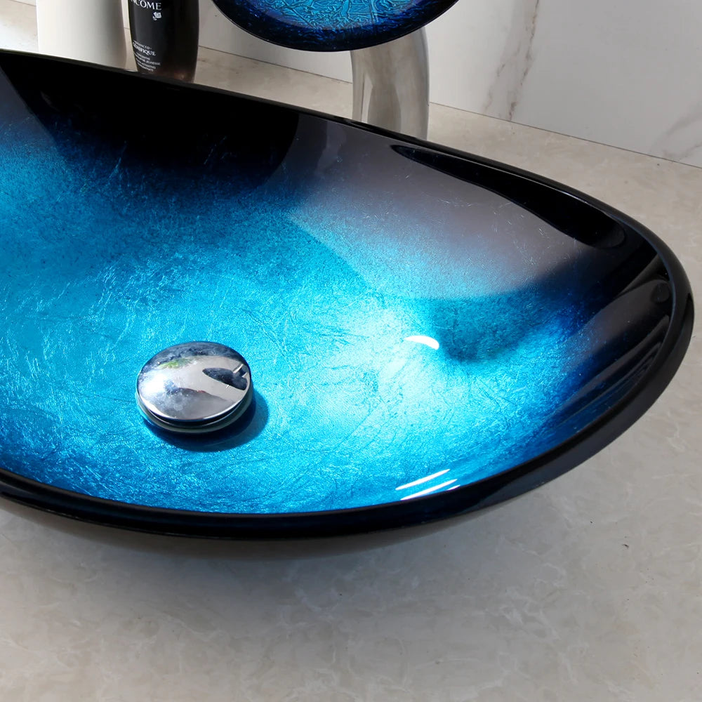 MC THE BLACK DIAMOND ZAPPO tempered glass bathroom vessel sink with waterfall black faucet and oval blue basin, above counter installation.