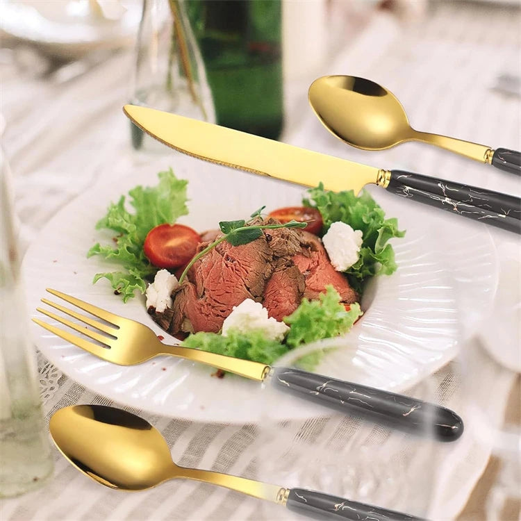 Stainless steel LMETJMA 24-piece flatware set with knives, forks, and spoons from MC The Black Diamonds, arranged on a table.