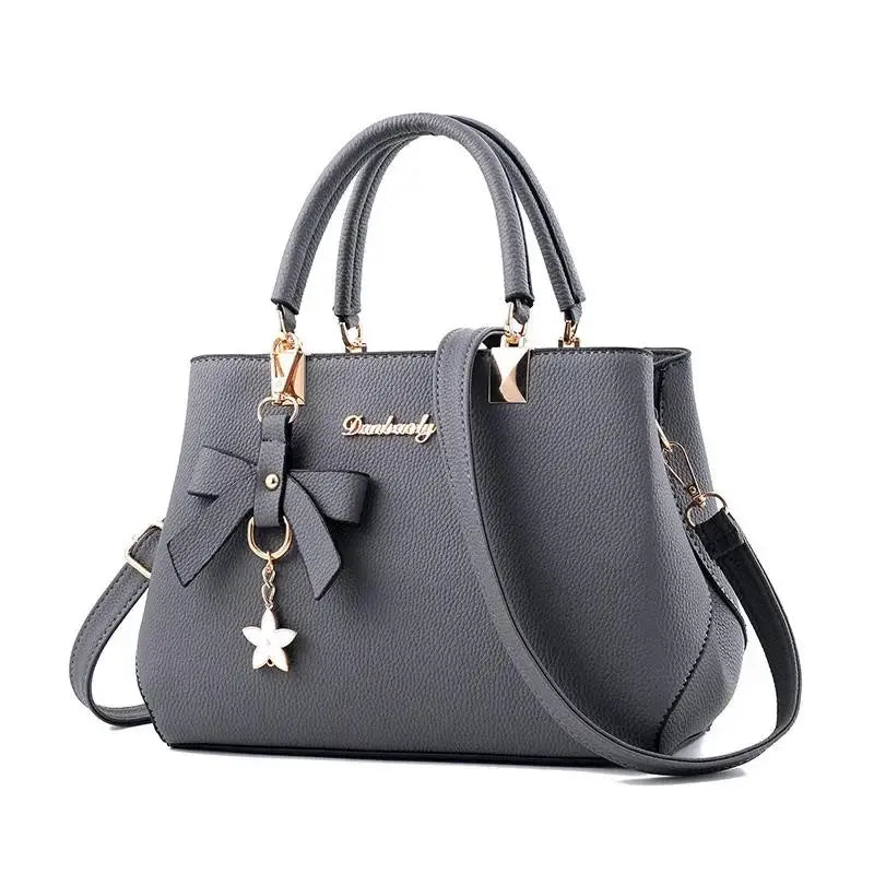 Women messenger bag with flower pendant, black leather tote from 𝕄𝕔 𝕋𝕙𝕖 𝔹𝕝𝕒𝕔𝕜 𝔻𝕚𝕒𝕞𝕠