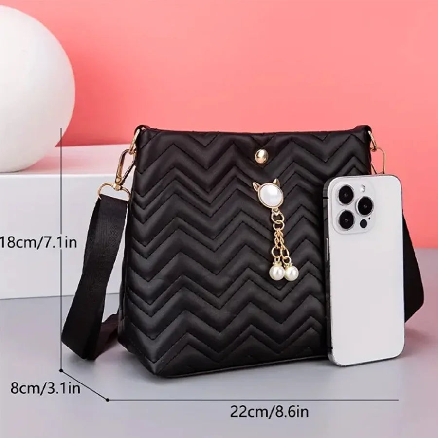 Women's quilted MC THE BLACK DIAMOND crossbody bag with cat pearl pendant, stylish shoulder handbag for holiday gifts.