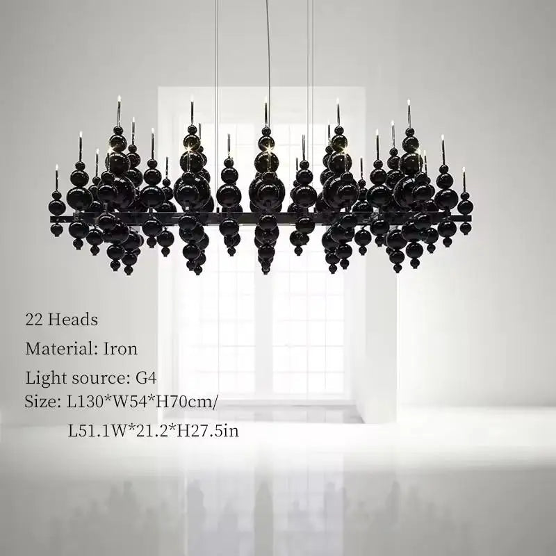 Luxury MC THE BLACK DIAMOND black chandelier with tear-shaped moon design, hanging from ceiling above dining table.